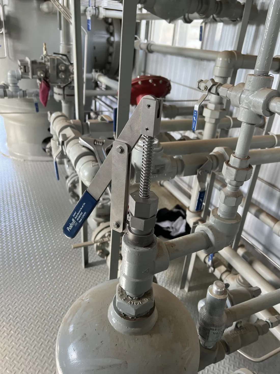 A Pushoff 2000 installed on a scrubber inside a gas facility building, surrounded by piping and valves